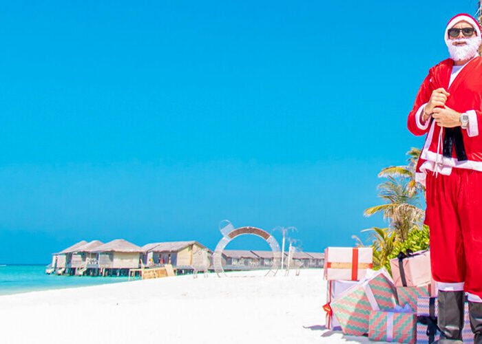 a picture of a male and female tourist celebrating christmas on an egyptian beach