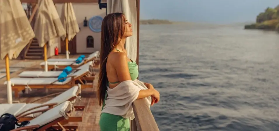 Solo Nile Cruise Adventure: A Complete Guide from an Egypt-Based Travel Expert 1 A stunning photo of a tourist standing on the deck of a Nile cruise ship