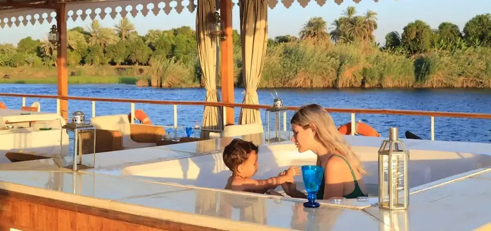 Nile Cruise with Kids: What to Know Before You Book 1 A mother and child relaxing in a hot tub on a cruise ship deck along a river